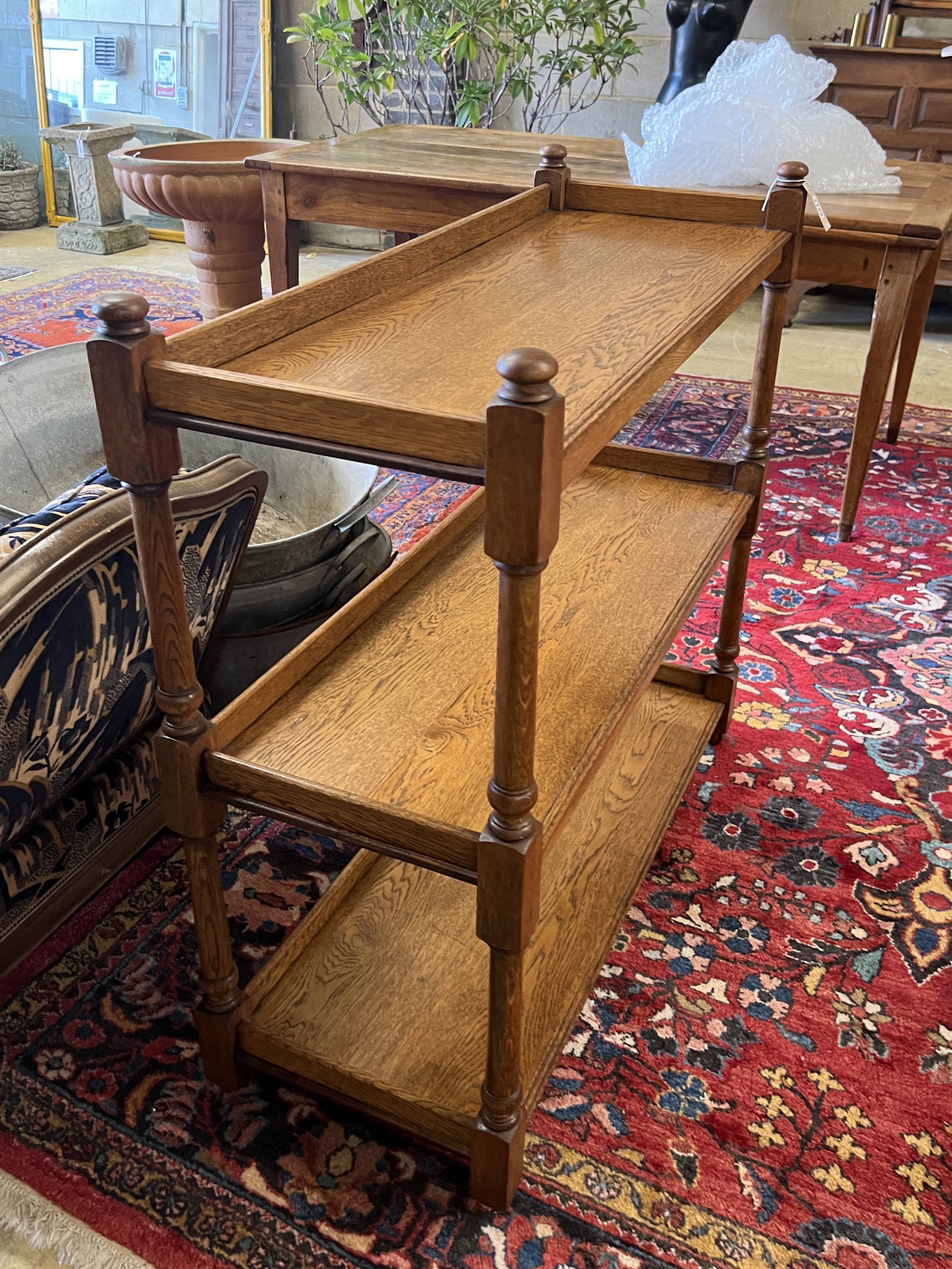 A late 19th / early 20th oak three tier buffet bears Jas Shoolbred & Co ivorine trade label, width 99cm, depth 38cm, height 95cm